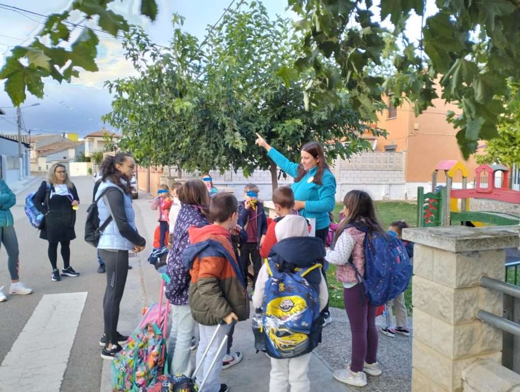 la monitora acompaña a los chicos y chicas al colegio mientras les explica la floración